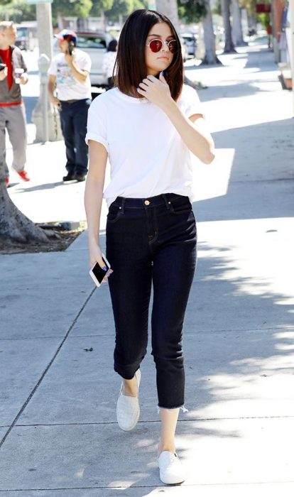 Selena caminando por las calles usando jeans y camisa blanca