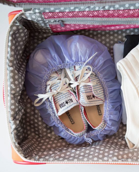 zapatos guardados en gorra de baño dentro de maleta