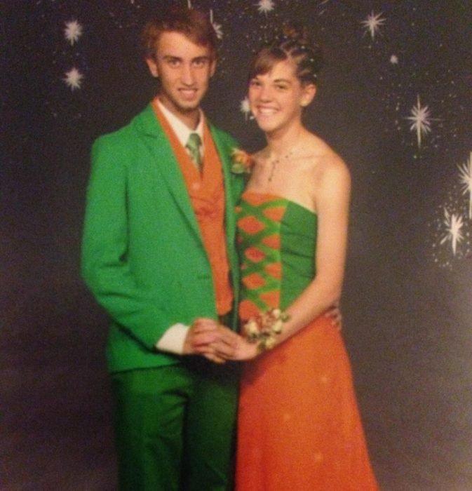 Chico usando un traje verde con naranja y chica usando un vestido con colores verde y naranja 
